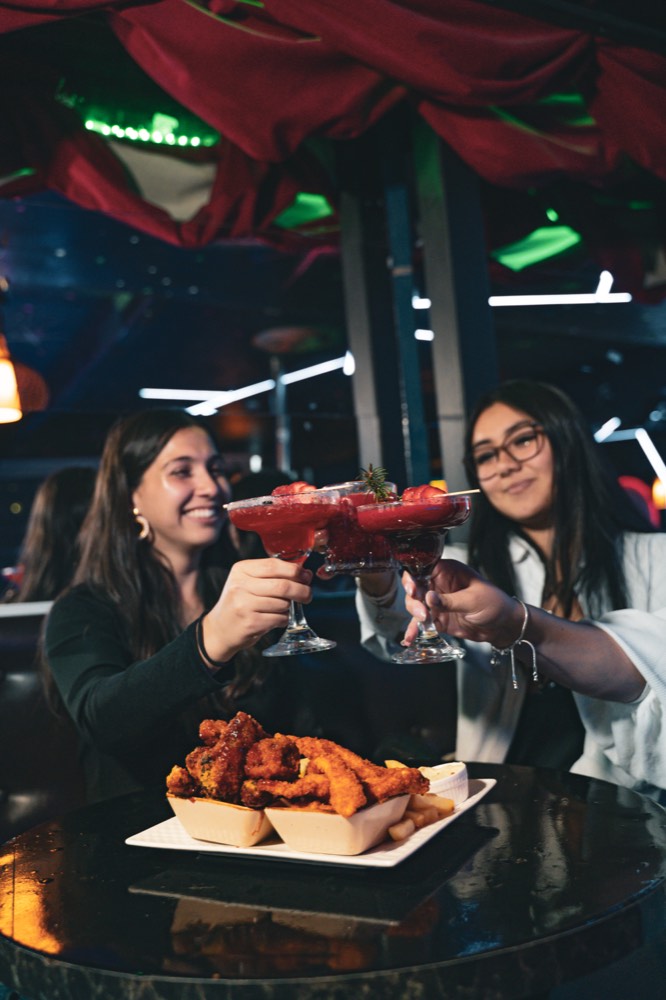 Brindis con margaritas y alitas de pollo